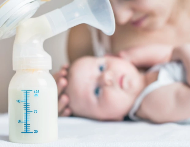 Criança olhando para bombinha de leite materno