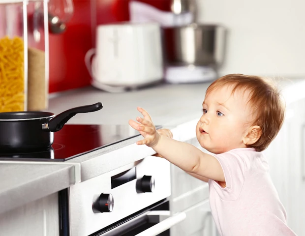 Criança tentando pegar panela no fogão